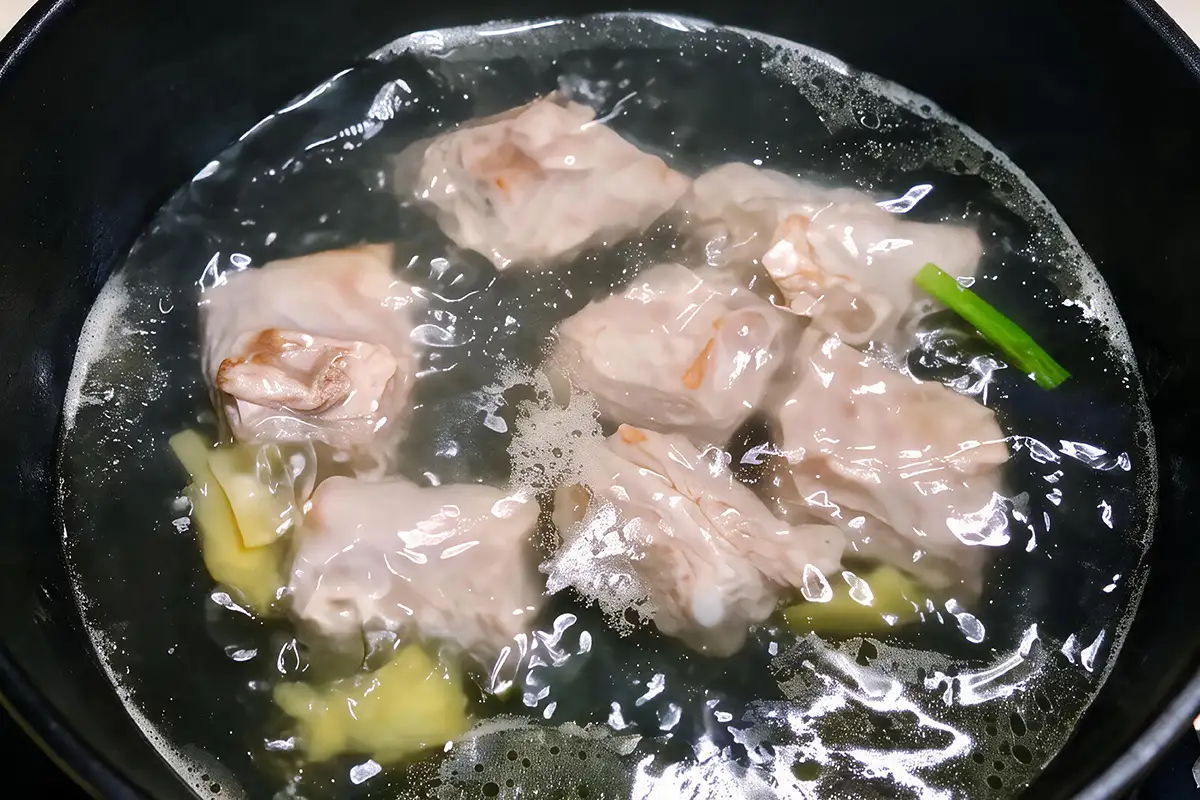 Pork ribs simmering as the blanch water heats up with ginger and scallion